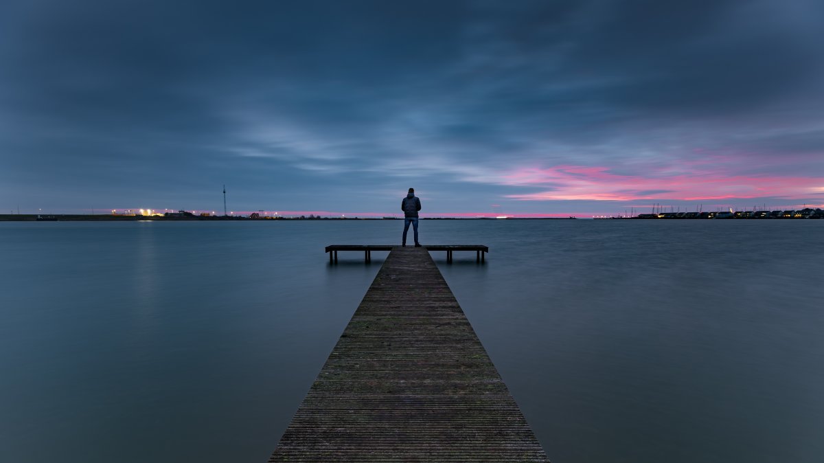 Dark clouds gather over the Zuiderhaven pier during the serene blue hour, Den Oever, Netherlands. (Shutterstock Photo)
