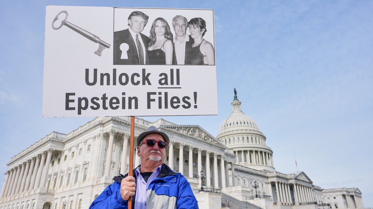 A man holds a sign before a news conference on the Epstein files in front of the Capitol, in Washington, U.S., Nov. 18, 2025. (AP Photo)