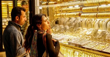 People look at gold jewelry as they stand outside a jewelry shop at the Grand Bazaar, Istanbul, Türkiye, Jan. 26, 2026. (Reuters Photo)