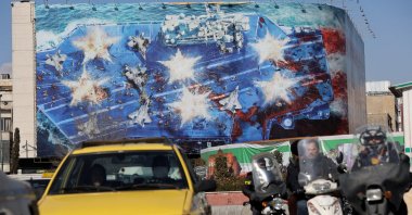People drive past an anti-U.S. billboard, Tehran, Iran, Jan. 31, 2026. (Reuters Photo)