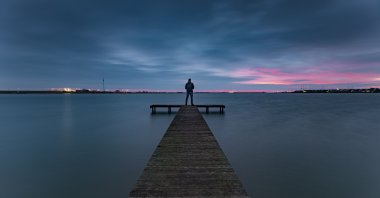 Dark clouds gather over the Zuiderhaven pier during the serene blue hour, Den Oever, Netherlands. (Shutterstock Photo)