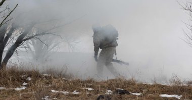 A Ukrainian serviceman goes through the smoke during a training at an undisclosed location in the Zaporizhzhia region, Ukraine, Jan. 30, 2026. (AFP Photo)