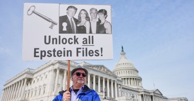 A man holds a sign before a news conference on the Epstein files in front of the Capitol, in Washington, U.S., Nov. 18, 2025. (AP Photo)