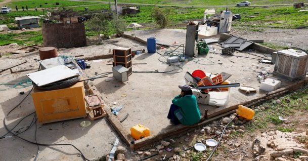 A Palestinian woman sits as members of a Palestinian Bedouin community leave following Israeli settler violence, in Ein al-Auja near Jericho, in the Israeli-occupied West Bank, Jan. 24, 2026. (Reuters Photo)