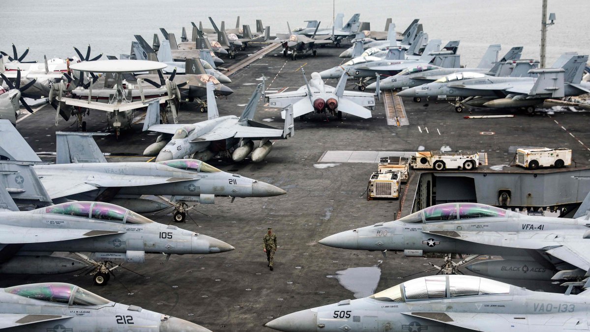 A U.S. Navy officer walks past fighter jets sitting on the flight deck of the Nimitz-class aircraft carrier USS Abraham Lincoln during a media tour in Port Klang, on the outskirts of Kuala Lumpur, Nov. 26, 2024. (AFP File Photo)