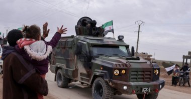 People wave, as internal security forces affiliated with the Syrian government prepare to enter the city of Qamishli, Syria, Feb. 3, 2026. (Reuters Photo) 