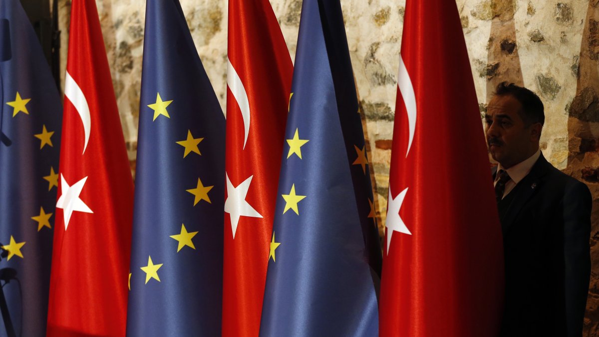 An official adjusts Turkish and European flags prior to the opening session of a high-level meeting, Istanbul, Türkiye, Feb.28, 2019. (AP Photo)