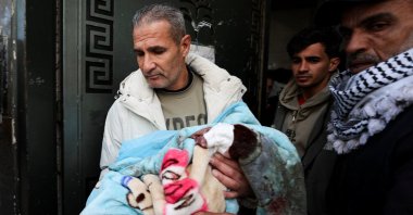 A mourner carries the body of a Palestinian child killed in an Israeli strike Wednesday at al-Shifa Hospital in Gaza City, Palestine, Feb. 4, 2026. (Reuters Photo)