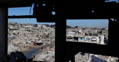 Palestinians walk past the rubble of residential buildings destroyed during Israel's two-year offensive, Gaza City, Palestine, Feb. 4, 2026. (Reuters Photo)