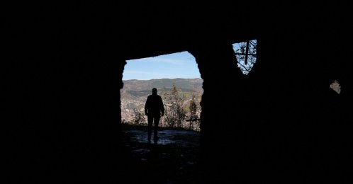 A Bosnian worker looks out at Sarajevo through a hole in a war-damaged building that once marked the front line during the 1992-95 Bosnian War, in Sarajevo, Bosnia-Herzegovina, Nov. 13, 2025. (Reuters File Photo)