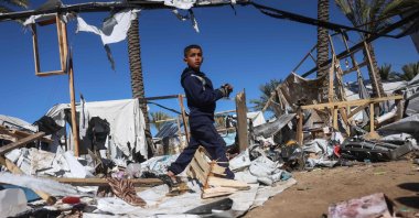 A boy makes his way through debris following an Israeli strike on a camp for displaced Palestinians in Khan Younis in the southern Gaza Strip, Palestine, Feb. 4, 2026. (AFP Photo)