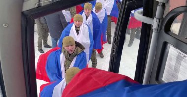 Russian prisoners of war (POWs) board a bus following an exchange of prisoners at an undisclosed location in Belarus, Feb. 5, 2026. (AFP Photo)