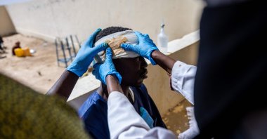 Mahamat Hamid Abakar, 33, who suffered head and leg injuries during a drone attack on the vehicle he was traveling in near Um Baru, Sudan, is being treated by nurses at the hospital in Tine, Wadi Fira, Chad, Jan. 30, 2026. (AFP Photo)
