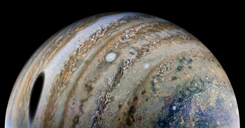 An enhanced-color image, using raw data from the JunoCam instrument aboard NASA's Juno spacecraft, shows the planet Jupiter, with a shadow of its moon Ganymede on the left, released by NASA on April 21, 2022. (Reuters Photo)