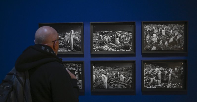 A visitor views photos of Göbeklitepe at the “Building Community: Göbeklitepe, Taş Tepeler and Life 12,000 Years Ago” exhibition, Berlin, Germany, Feb. 5, 2026. (AA Photo)