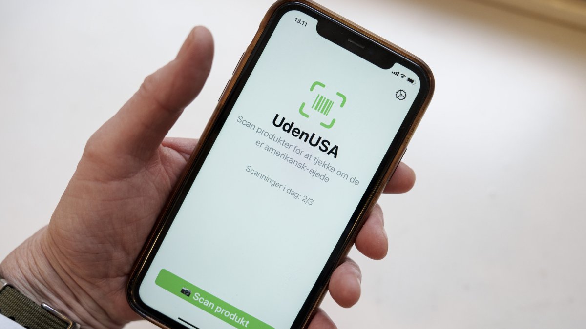 A close-up shows a mobile phone displaying the app UdenUSA, which translates to Without USA in Danish, Copenhagen, Denmark, Jan. 21, 2026.  (EPA Photo)