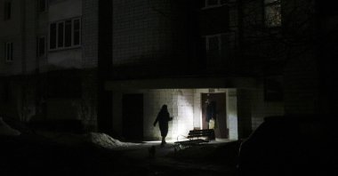 A person walks with a flashlight in a dark street during a power cut, Lviv, Ukraine, Feb. 7, 2026. (EPA Photo)