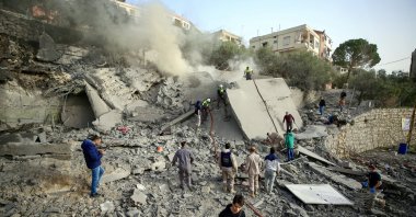 Civil Defense workers and civilians inspect a destroyed building following an Israeli airstrike in Ain Qana village, in southern Lebanon, Feb. 2, 2026. (EPA Photo)