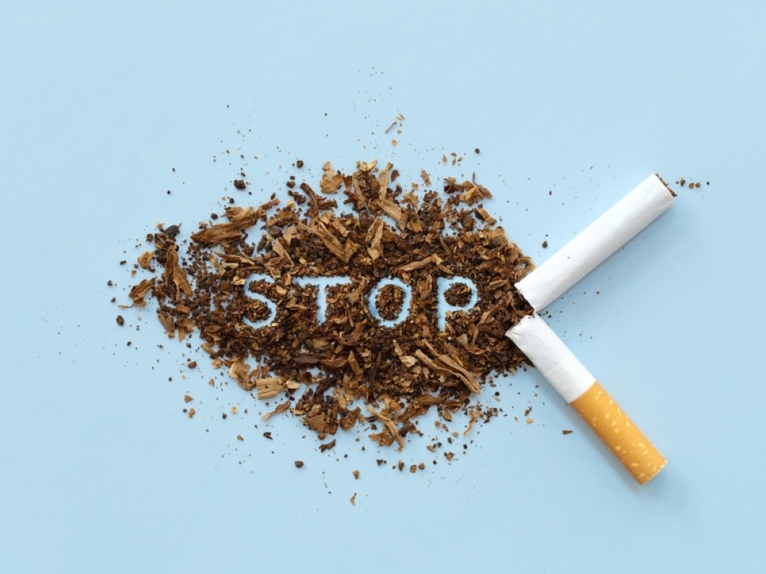 Broken cigarette and scattered tobacco with the word "STOP" on a light blue background. (Shutterstock Photo)