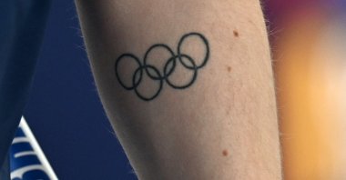A general view of a tattoo of the Olympic rings on the arm of Britain’s Bruce Mouat during the mixed doubles curling round-robin match between Great Britain and Estonia during the Milano-Cortina 2026 Winter Olympics at the Cortina Curling Olympic Stadium, Cortina d’Ampezzo, Italy, Feb. 5, 2026. (Reuters Photo)