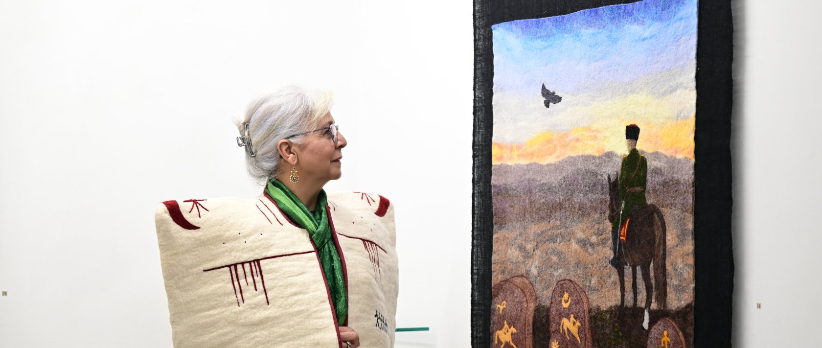 Felt artist Nur Sağlamer looks at her artwork on display at the "Aşina" exhibition at Galeri T in Antalya, southern Türkiye, Feb. 5, 2026. (AA Photo)