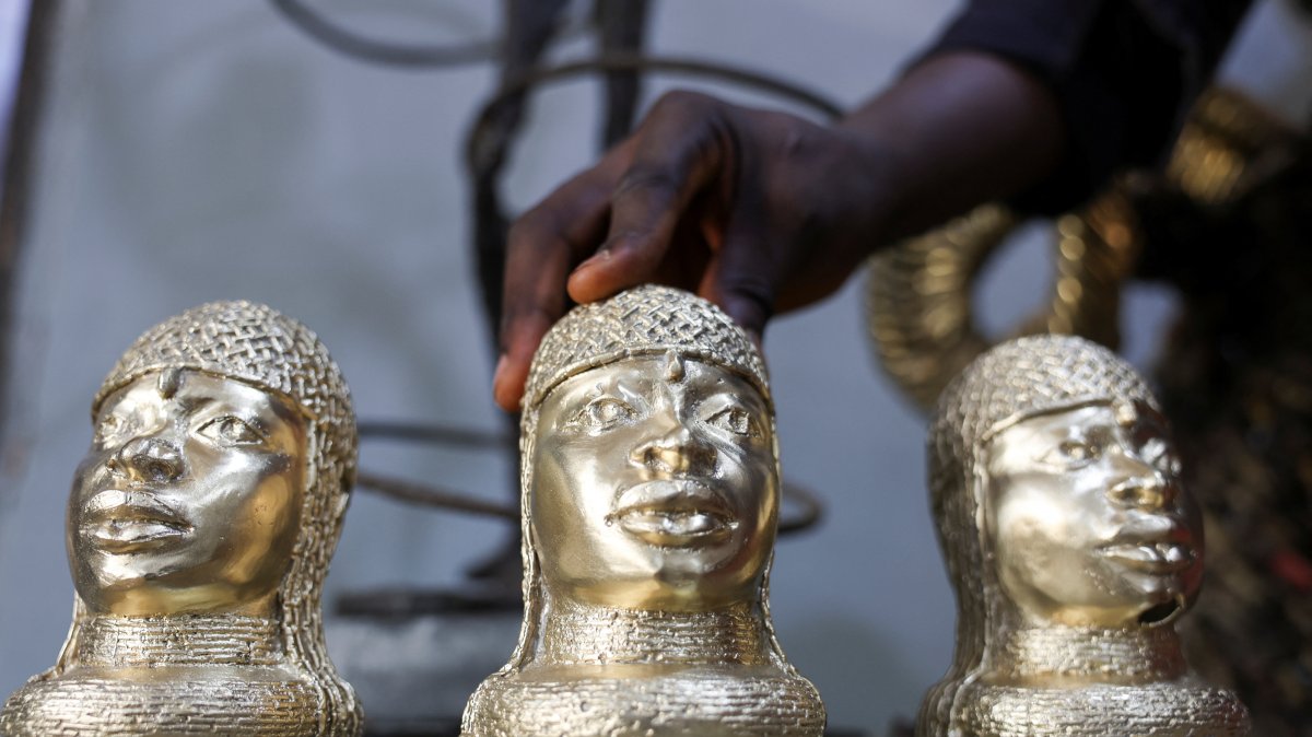 Bronze caster Kelly Omodamwen, 32, from a family of casters, displays sets of Benin bronze pieces at his workshop in Benin City, Edo State, Nigeria, Feb. 2, 2026. (Reuters Photo)