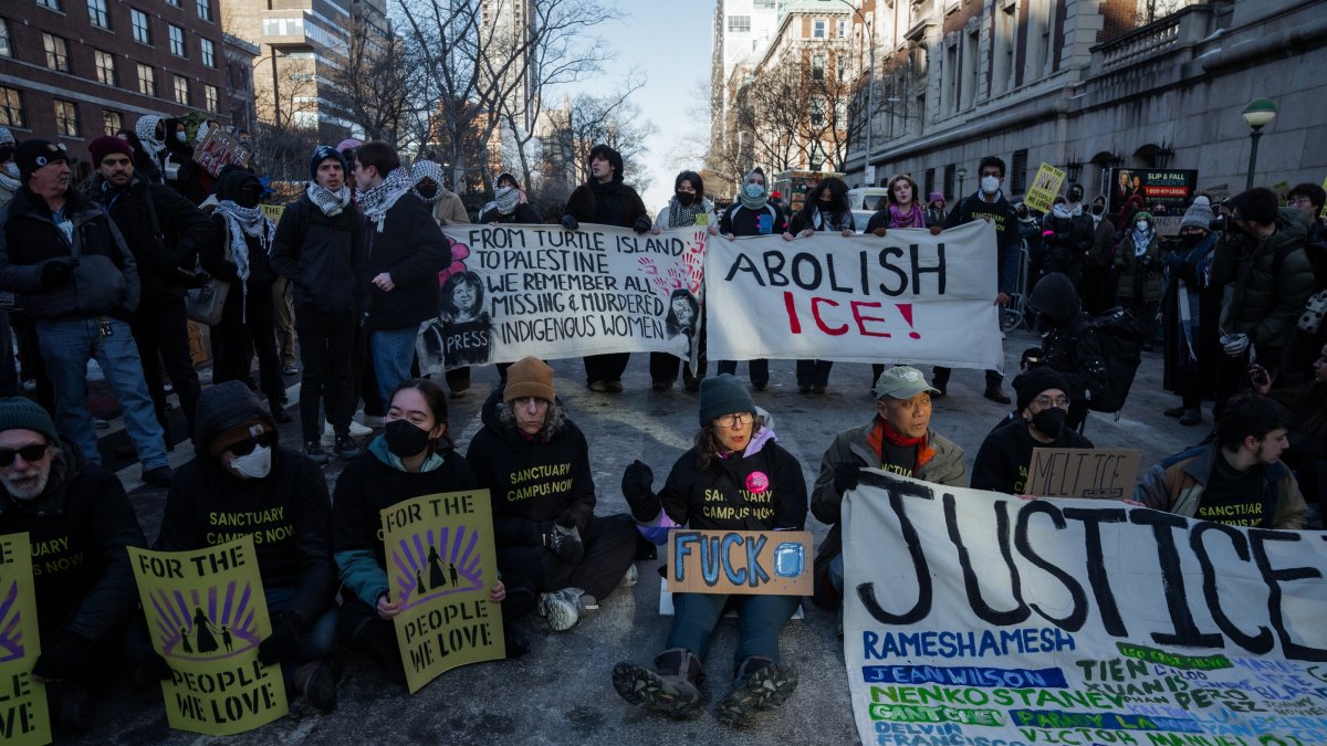 People hold signs as they block a road in an act of civil disobedience outside Columbia University during an anti-ICE protest in New York, New York, Feb. 5, 2026. (EPA Photo)