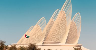 A United Arab Emirates flag waves in front of the contemporary Zayed National Museum, Abu Dhabi, UAE, Dec. 6, 2025. (Shutterstock Photo)
