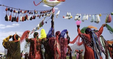 Qashqai women in traditional dress dance in a group while spinning colorful scarves in their hands during a wedding ceremony on the plains near Shiraz, Iran, April 28, 2006. (Getty Images Photo)