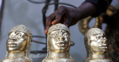 Bronze caster Kelly Omodamwen, 32, from a family of casters, displays sets of Benin bronze pieces at his workshop in Benin City, Edo State, Nigeria, Feb. 2, 2026. (Reuters Photo)