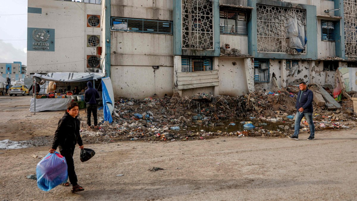 People walk outside a make-shift camp for those displaced by conflict in Al-Rimal school run by the United Nations Relief and Works Agency for Palestine Refugees (UNRWA) in the northern Gaza Strip, Jan. 28, 2026. (AFP Photo)