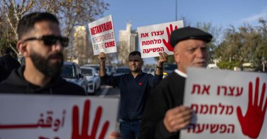 Protesters hold placards, calling on the government to take action to curb soaring violent crime against Arab Israeli communities, West Jerusalem, Feb. 8, 2026. (AFP Photo)