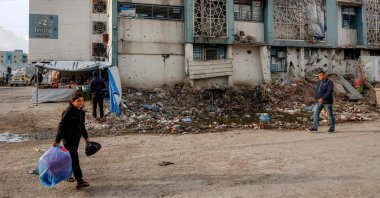 People walk outside a make-shift camp for those displaced by conflict in Al-Rimal school run by the United Nations Relief and Works Agency for Palestine Refugees (UNRWA) in the northern Gaza Strip, Jan. 28, 2026. (AFP Photo)