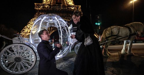 A Dutch couple poses in front of the Eiffel Tower as they take part in a Cinderella-themed marriage proposal prior to Saint Valentine's day, Paris, France, Feb. 7, 2026. (afp pHOTO)