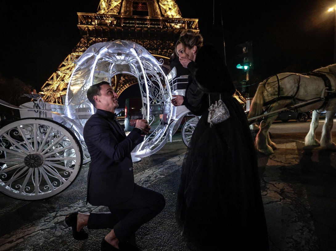 A Dutch couple poses in front of the Eiffel Tower as they take part in a Cinderella-themed marriage proposal prior to Saint Valentine's day, Paris, France, Feb. 7, 2026. (afp pHOTO)