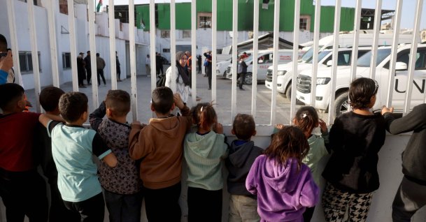 Palestinian children watch as war-wounded Palestinians and other patients prepare to leave the Gaza Strip for treatment through the Rafah border crossing between the Gaza Strip and Egypt after it was opened by Israel for a limited number of people, in Khan Yunis in the southern Gaza Strip, Feb. 8, 2026. (AFP Photo)