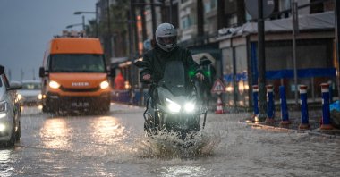 Heavy rainfall disrupts daily life as water accumulates along the streets, affecting drivers and pedestrians, Izmir, Türkiye, Feb. 5, 2026. (AA Photo)