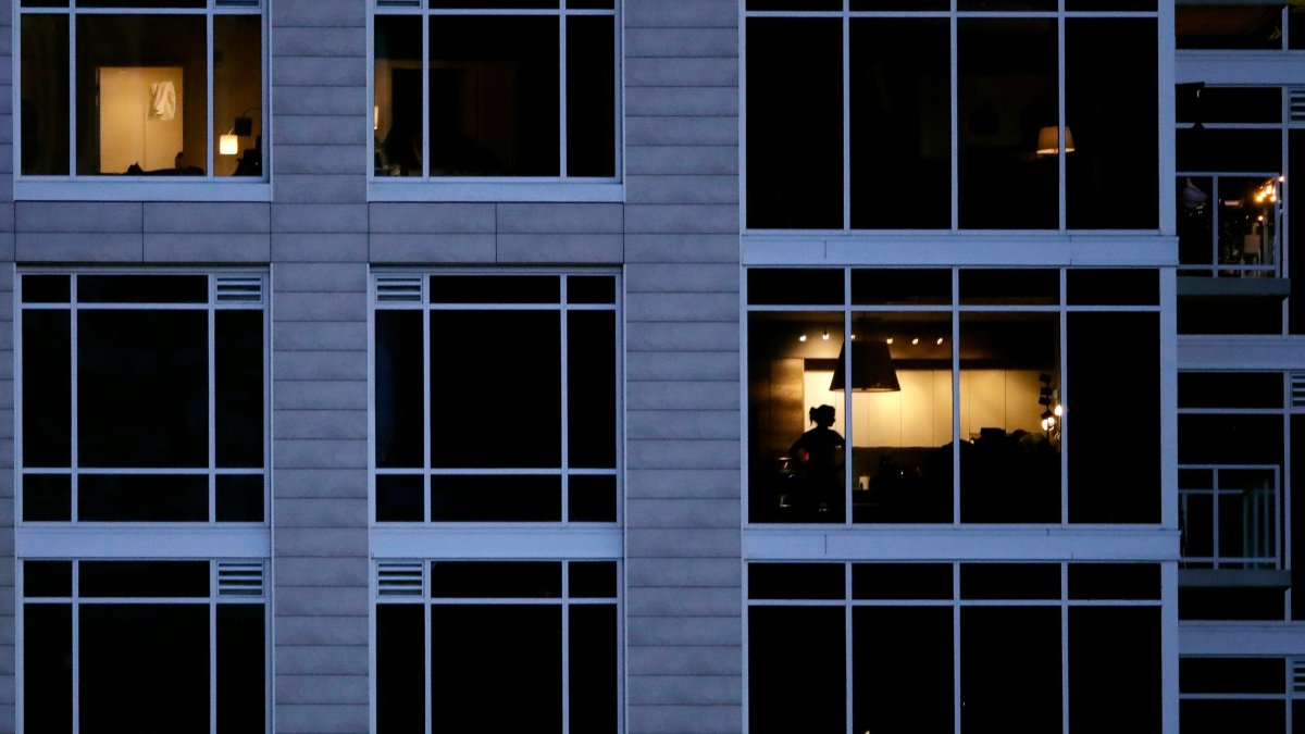 A person looks out of a window in an apartment building, Kansas City, U.S., May 3, 2020. (AP Photo)