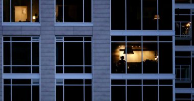 A person looks out of a window in an apartment building, Kansas City, U.S., May 3, 2020. (AP Photo)