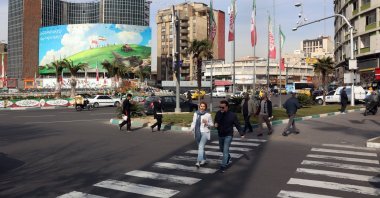 Iranians walk past an anti-U.S. billboard in Tehran, Iran, Feb. 14, 2026. (EPA Photo)