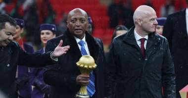 CAF President Patrice Motsepe (C) holds the Africa Cup of Nations trophy alongside FIFA President Gianni Infantino (R) during the presentation following the final between Senegal and Morocco at Prince Moulay Abdellah Stadium, Rabat, Morocco, Jan. 18, 2026. (Reuters Photo)