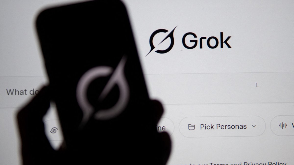 The Grok website is seen on a computer screen next to a mobile phone displaying the logo, Bogota, Colombia, Feb. 12, 2026. (AFP Photo)