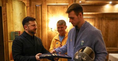 Ukrainian President Volodymyr Zelensky awards Ukrainian skeleton athlete Vladyslav Heraskevych a medal as they meet, Munich, Germany, Feb. 13, 2026. (AFP Photo)