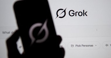 The Grok website is seen on a computer screen next to a mobile phone displaying the logo, Bogota, Colombia, Feb. 12, 2026. (AFP Photo)