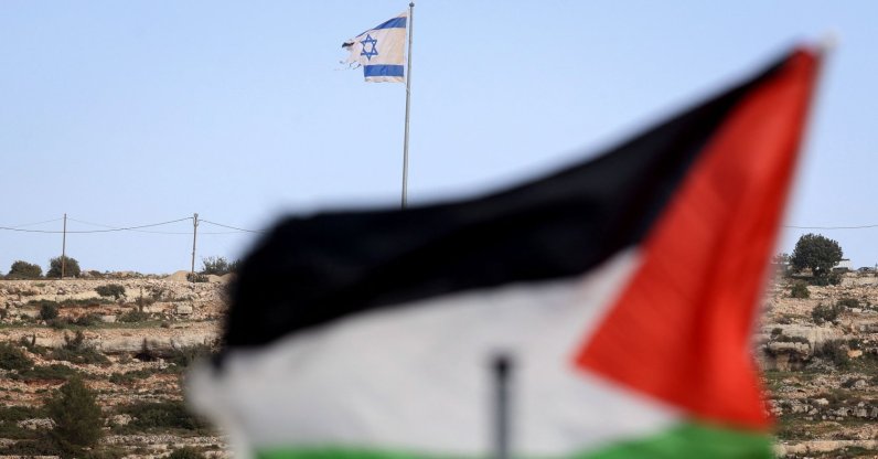 A Palestinian flag flutters with an Israeli flag in backgroud on a hilltop overlooking the village of Umm Safa, north of Ramallah, occupied West Bank, Palestine, Feb. 16, 2026.