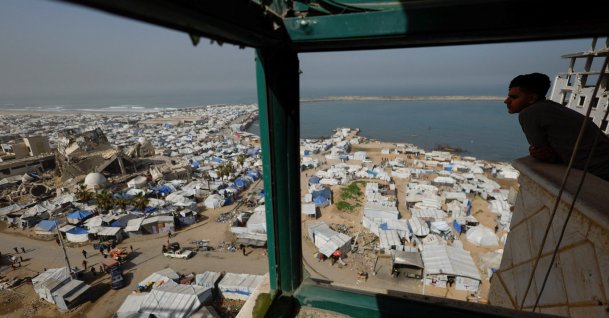 A Palestinian looks at a mosque, destroyed during the two-year Israeli offensives, surrounded by tents for displaced Palestinians, in Gaza City, Feb. 15, 2026. (Reuters Photo)