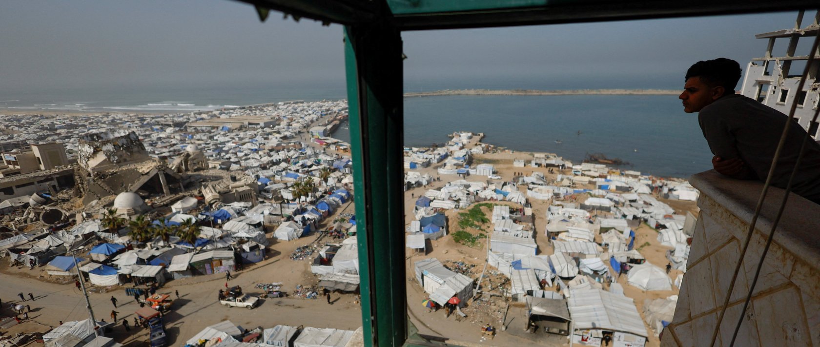 A Palestinian looks at a mosque, destroyed during the two-year Israeli offensives, surrounded by tents for displaced Palestinians, in Gaza City, Feb. 15, 2026. (Reuters Photo)