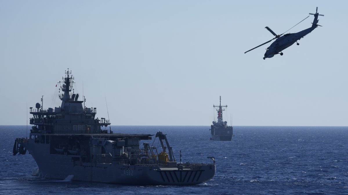 A military helicopter flies over naval ships during an annual NATO naval exercise on Türkiye’s western coast on the Mediterranean, Sept. 15, 2022. (AP Photo)