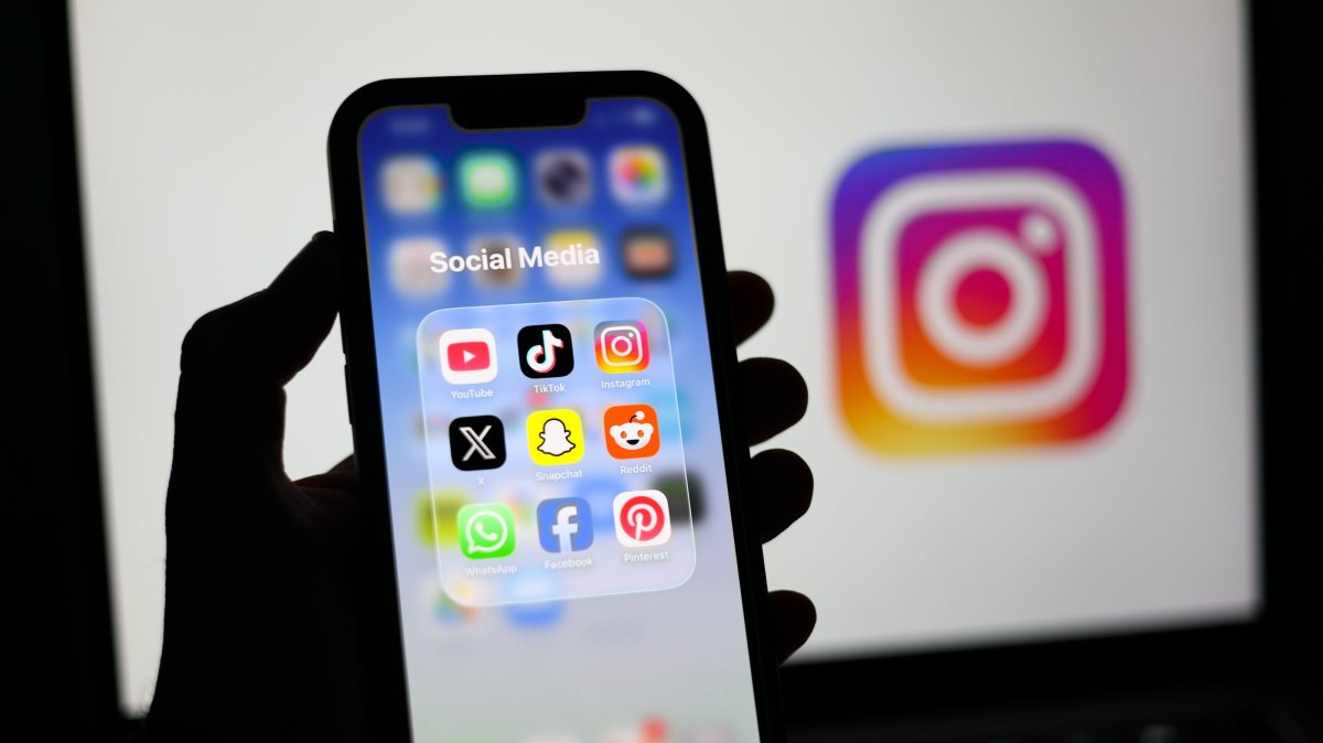 Social media applications are displayed on a mobile phone alongside the Instagram logo on a laptop screen, Liverpool, Britain, Jan. 23, 2026. (EPA Photo)