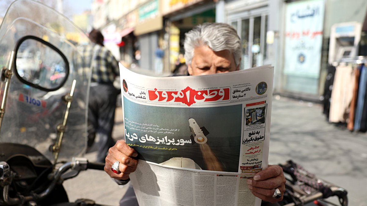 A man reads the Iranian daily newspaper Vatan-e Emrooz featuring a headline "Sea surprises," outside a kiosk in Tehran, Iran, Feb. 19, 2026. (EPA Photo)